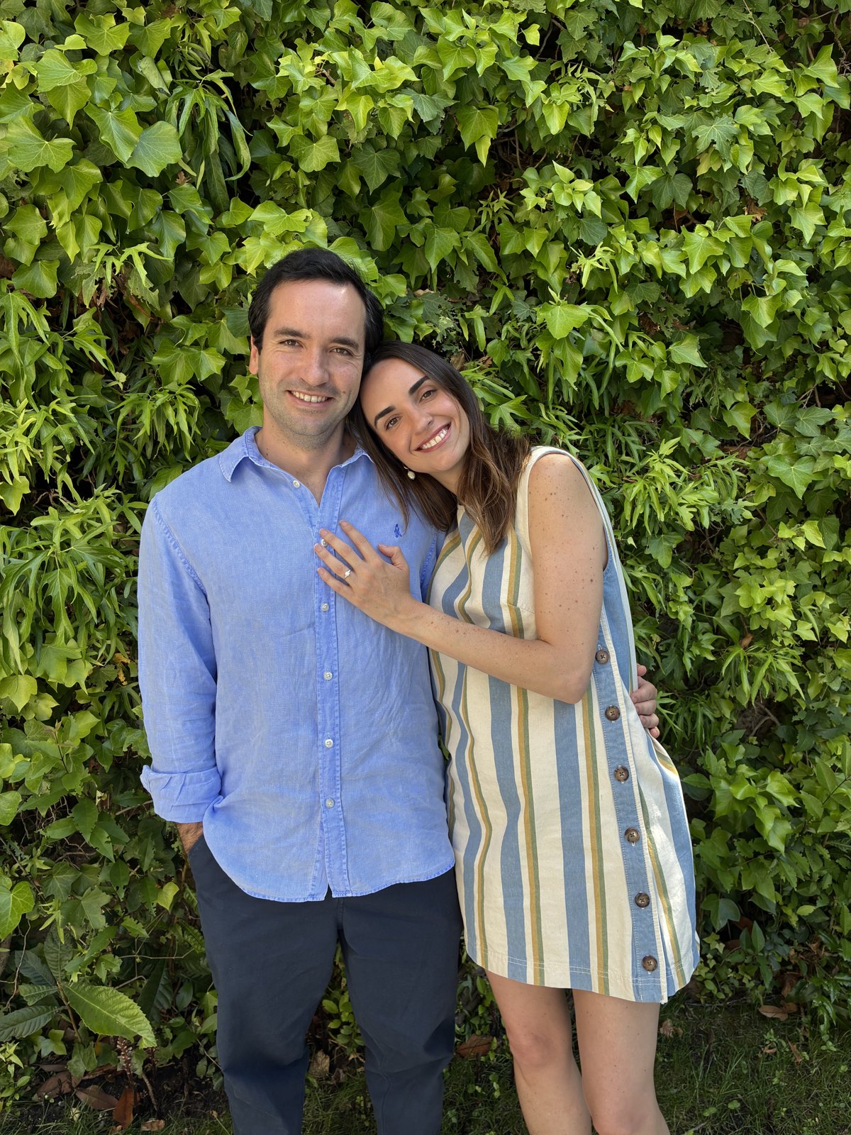 Lorenzo y Almudena abrazados frente a un muro de hiedra
